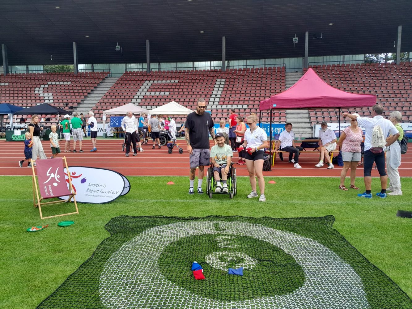 Foto: Sabine Stiehl Betreuer und Serviceteam spielen ein Sackwurfspiel mit einem Rollstuhlfahrer